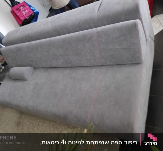 ספה אפורה עם ריפוד מרופד וכרית קטנה